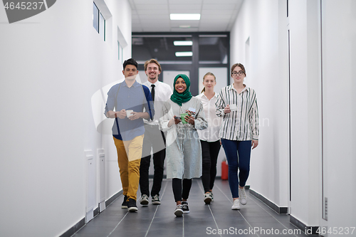 Image of multi-ethnic startup business team walking through the hallway