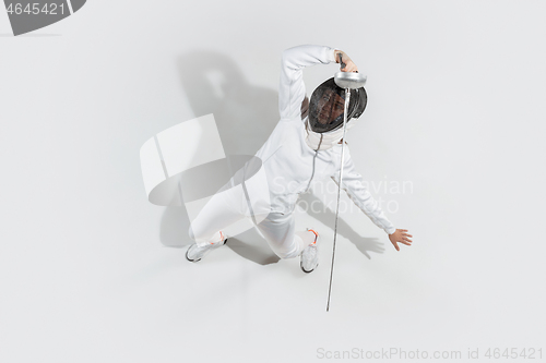 Image of Teen girl in fencing costume with sword in hand isolated on white background, top view