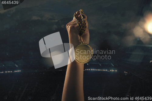 Image of Award of victory, male hands tightening the medal of winners against cloudy dark sky