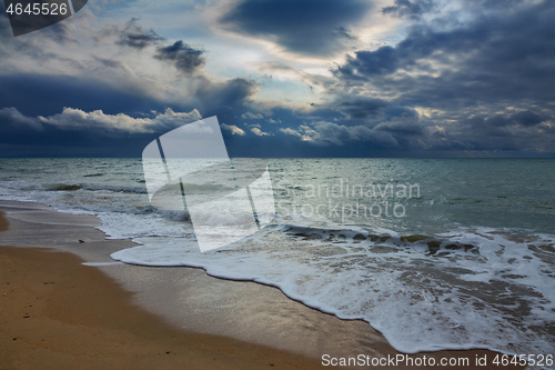 Image of stormy sky over sea and sandy beach