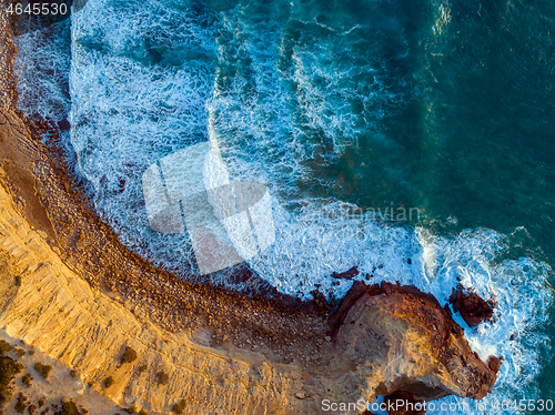 Image of Aerial top view on rock cliffs and waves