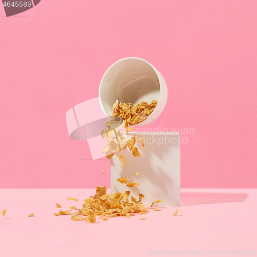 Image of cornflakes fall out of a white bowl
