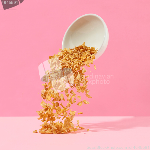 Image of cornflakes fall out of a white bowl