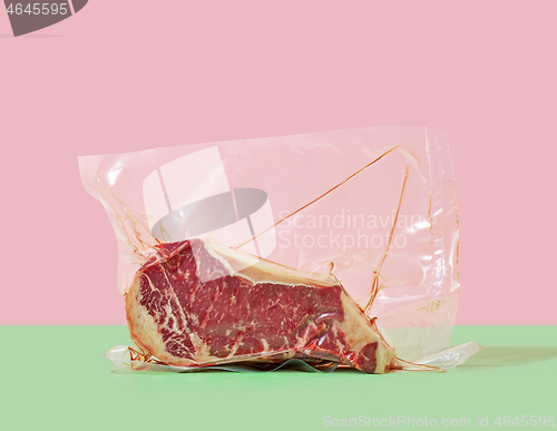 Image of steak in cellophane packaging on a colored background