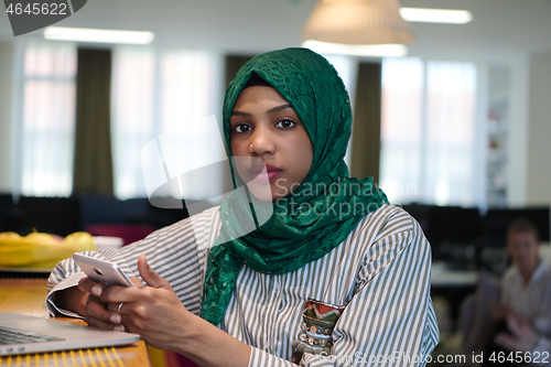 Image of african muslim business woman using mobile phone