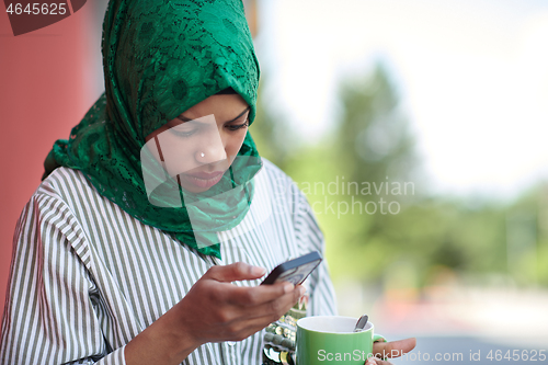 Image of african muslim businesswoman using mobile phone