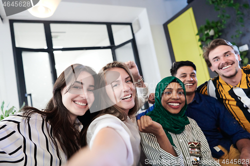 Image of group of casual multiethnic business people taking selfie