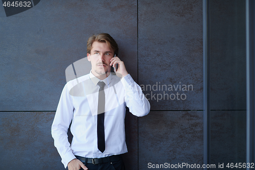 Image of startup businessman in a white shirt with a tie using mobile pho