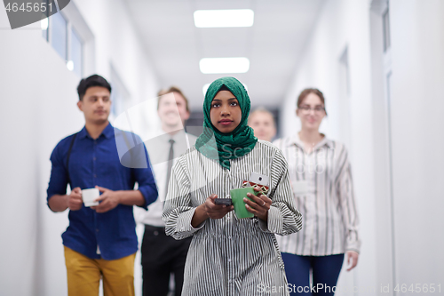 Image of multi-ethnic startup business team walking through the hallway