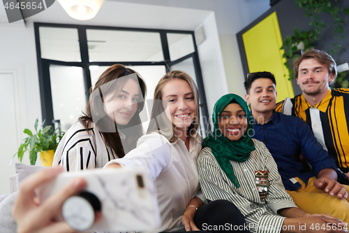 Image of group of casual multiethnic business people taking selfie