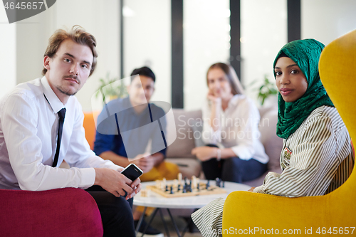 Image of multiethnic group of business people playing chess