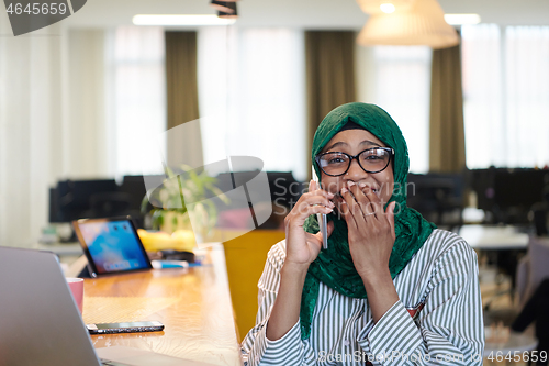 Image of african muslim business woman using mobile phone