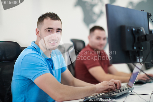 Image of two male software developers working on computer