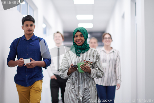 Image of multi-ethnic startup business team walking through the hallway