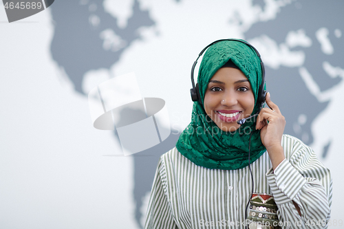 Image of African muslim female with phone headset helping and supporting 