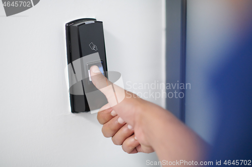 Image of man pressing fingerprint scanner