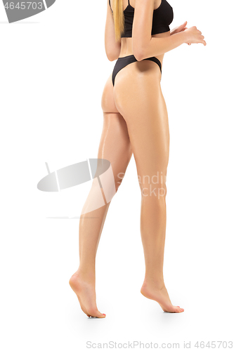 Image of Beautiful female legs isolated on white background. Sportive, sensual body with well-kept skin in underwear.