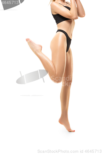 Image of Beautiful female legs isolated on white background. Sportive, sensual body with well-kept skin in underwear.