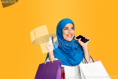 Image of Portrait of young muslim woman isolated on yellow studio background