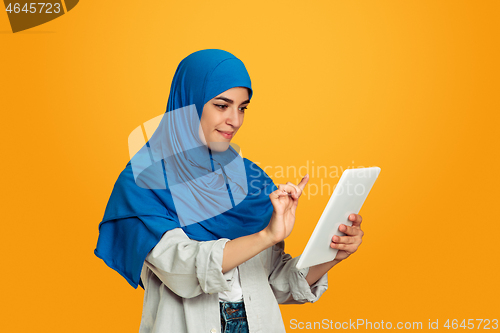 Image of Portrait of young muslim woman isolated on yellow studio background