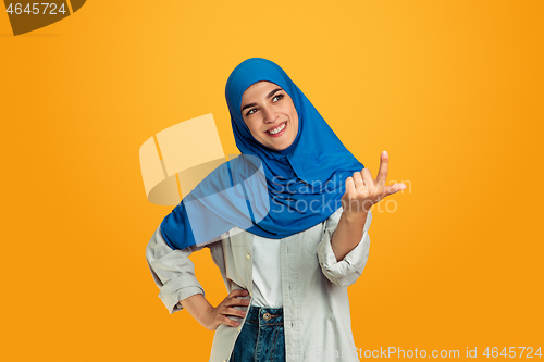 Image of Portrait of young muslim woman isolated on yellow studio background