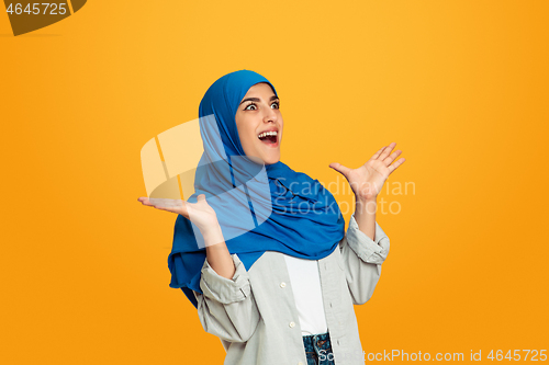 Image of Portrait of young muslim woman isolated on yellow studio background