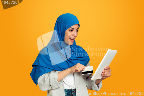 Image of Portrait of young muslim woman isolated on yellow studio background