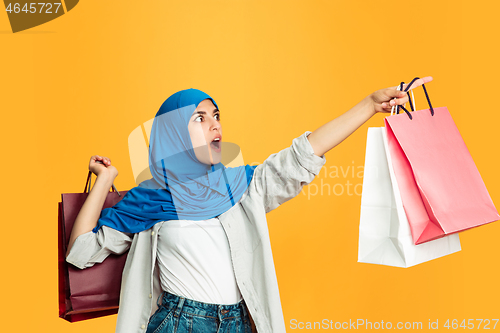 Image of Portrait of young muslim woman isolated on yellow studio background