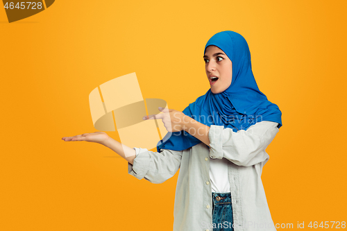 Image of Portrait of young muslim woman isolated on yellow studio background