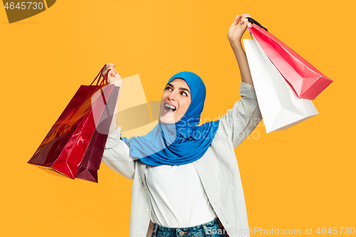 Image of Portrait of young muslim woman isolated on yellow studio background