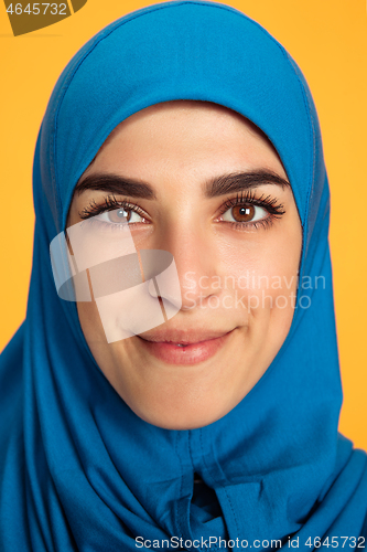 Image of Portrait of young muslim woman isolated on yellow studio background