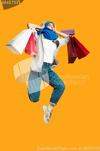 Image of Portrait of young muslim woman isolated on yellow studio background