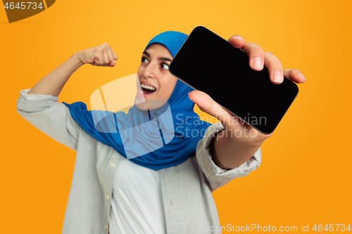 Image of Portrait of young muslim woman isolated on yellow studio background