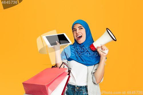 Image of Portrait of young muslim woman isolated on yellow studio background