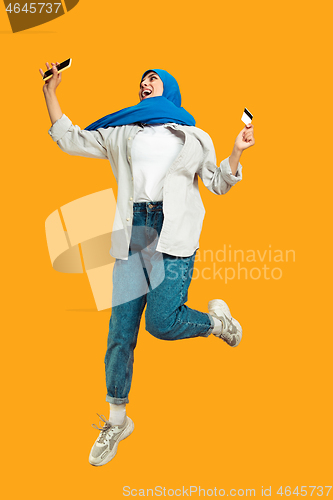 Image of Portrait of young muslim woman isolated on yellow studio background