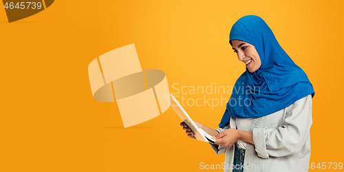 Image of Portrait of young muslim woman isolated on yellow studio background