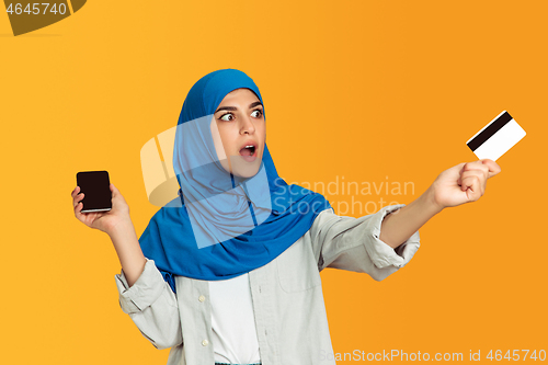 Image of Portrait of young muslim woman isolated on yellow studio background