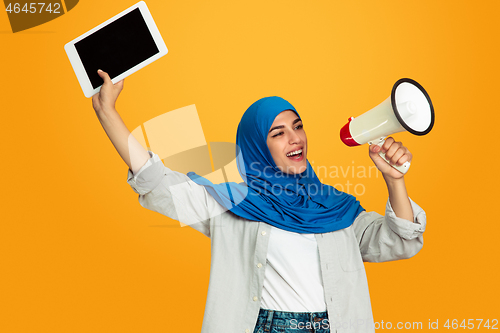 Image of Portrait of young muslim woman isolated on yellow studio background