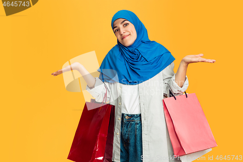 Image of Portrait of young muslim woman isolated on yellow studio background