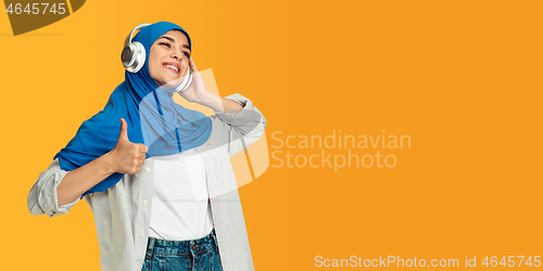 Image of Portrait of young muslim woman isolated on yellow studio background