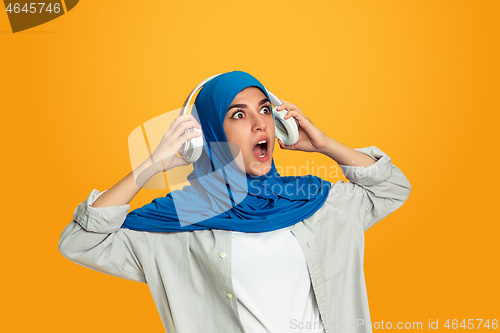 Image of Portrait of young muslim woman isolated on yellow studio background