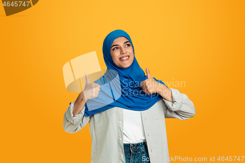 Image of Portrait of young muslim woman isolated on yellow studio background