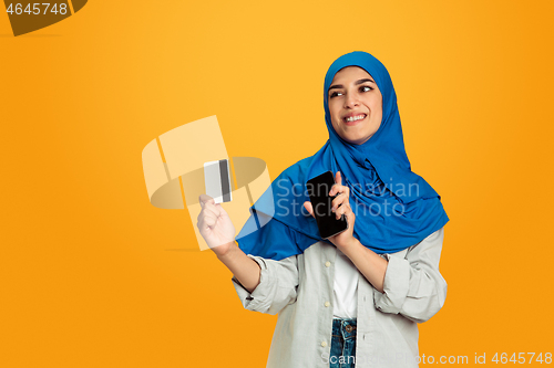 Image of Portrait of young muslim woman isolated on yellow studio background