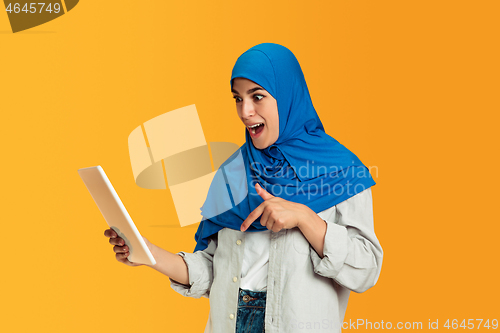 Image of Portrait of young muslim woman isolated on yellow studio background