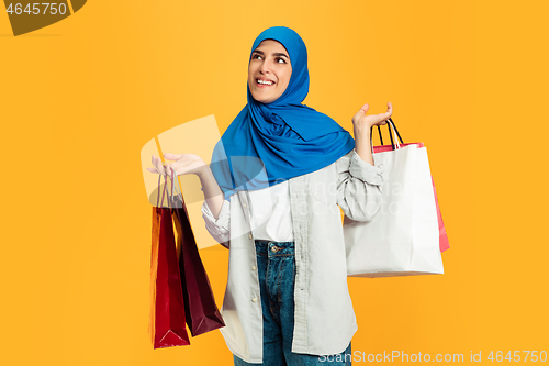 Image of Portrait of young muslim woman isolated on yellow studio background