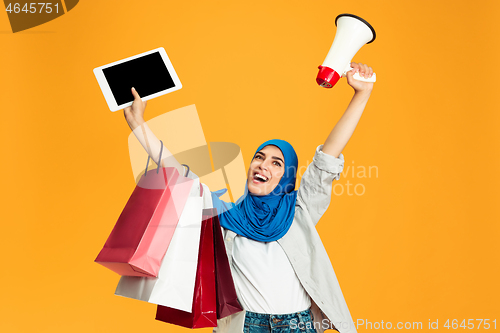 Image of Portrait of young muslim woman isolated on yellow studio background