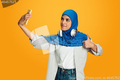 Image of Portrait of young muslim woman isolated on yellow studio background