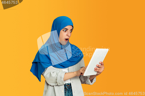 Image of Portrait of young muslim woman isolated on yellow studio background