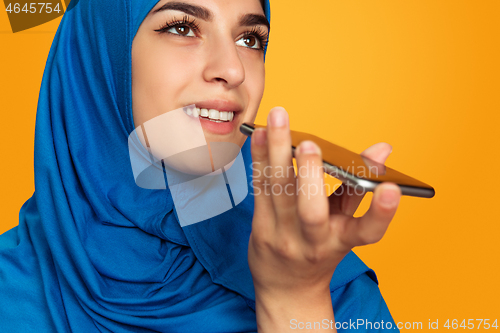 Image of Portrait of young muslim woman isolated on yellow studio background