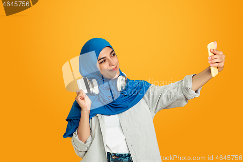 Image of Portrait of young muslim woman isolated on yellow studio background